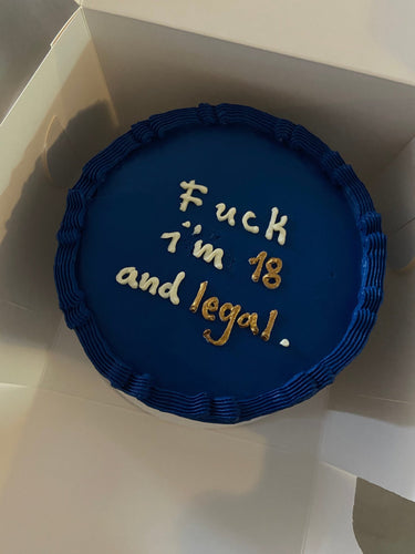 Кръгла торта с морскосиня глазура, кремав кант и златен надпис "Fuck I'm 18 and legal"