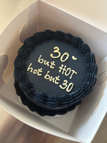 Кръгла торта с морскосиня глазура и кремав кант, с надпис '30 ♡ but HOT hot but 30'.