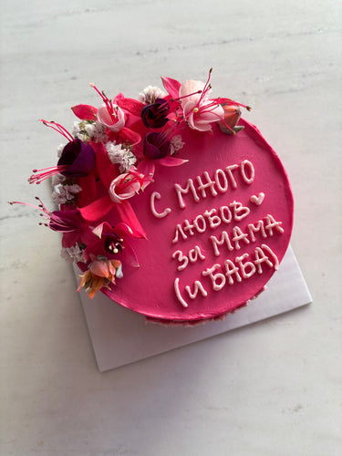 Кръгла розова торта с надпис 'С МНОГО любов за МАМА (и БАБА)' в тъмен шрифт върху розова глазура.