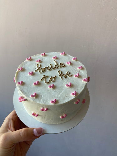 Кръгла бяла торта с златен надпис bride to be