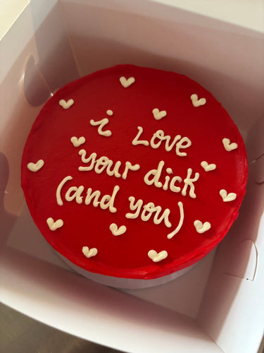 Кръгла червена торта с надпис 'i Love your dick (and you)' върху повърхността, без допълнителна украса.