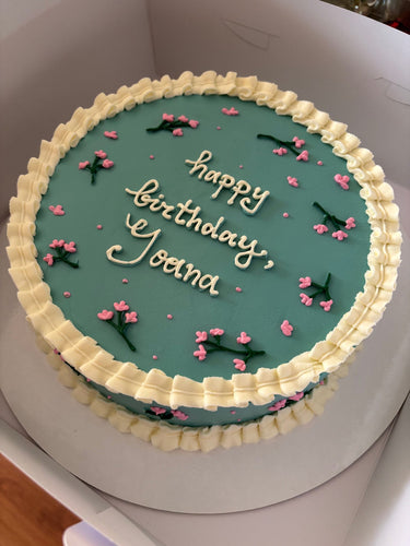 Кръгла ментова торта с пролетни цветя, кремав кант и надпис 'happy birthday'