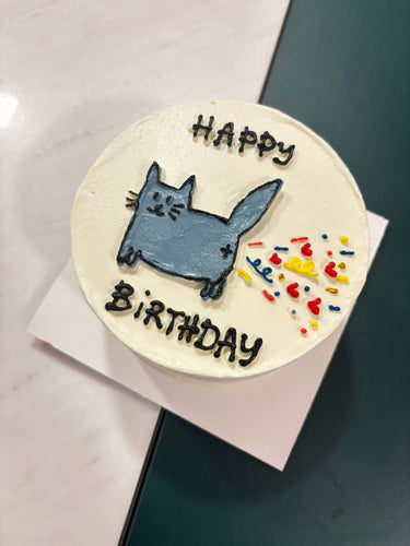 Кръгла бяла торта с рисунка на коте и надпис HAPPY BiRTHDAY