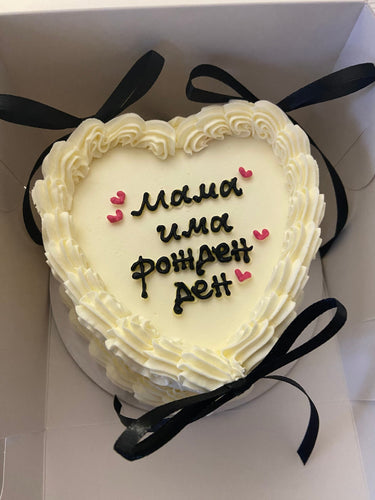 Кръгла кремава торта с надпис "мама има рожден ден", кремав кант и декоративни панделки.