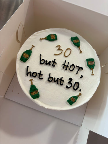Кръгла бяла торта с рисунка и златен надпис '30 but HOT, hot but 30.'