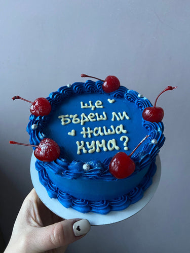 Кръгла синя торта с надпис 'Ще бъдеш ли наша кума?', украсена с черешки, бели перли и кремав кант.