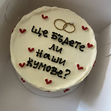 Кръгла кремава торта с надпис 'Ще бъдете ли наши кумове?' без допълнителна украса.