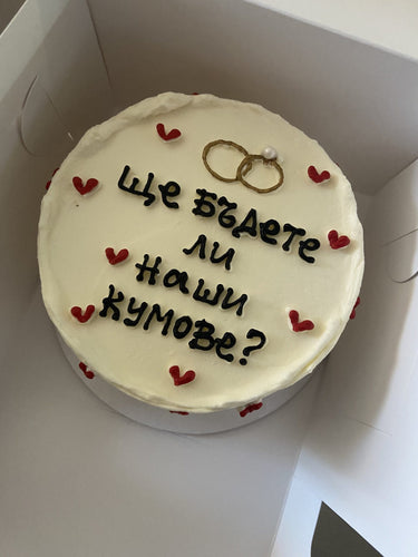 Кръгла кремава торта с надпис 'Ще бъдете ли наши кумове?' без допълнителна украса.