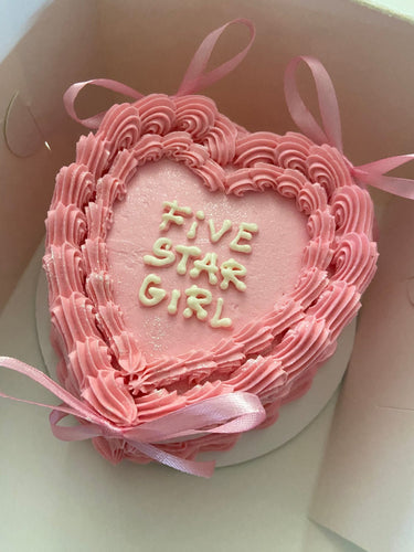 Розова торта сърце с надпис FIVE STAR GIRL, украсена с панделки, кремав кант и брокат.