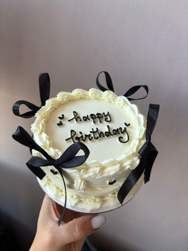 Кръгла кремава торта с панделки, кремав кант и надпис "happy birthday"