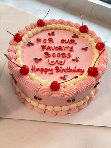 Кръгла розова торта с черешки и кремав кант. Надпис: FOR OUR FAVORITE BOOBS Happy Birthday.