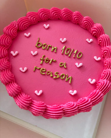 Кръгла розова торта с брокат, кремав кант и златен надпис "born 10/10 for a reason"
