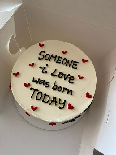 Кръгла бяла торта с надпис 'Someone i Love was born TODAY'.