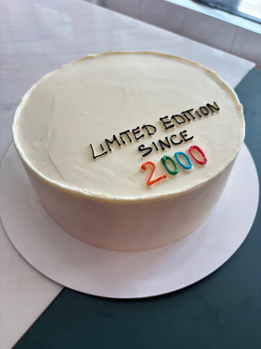 Кръгла кремава торта с рисунка и надпис 'Limited Edition Since 2000'.
