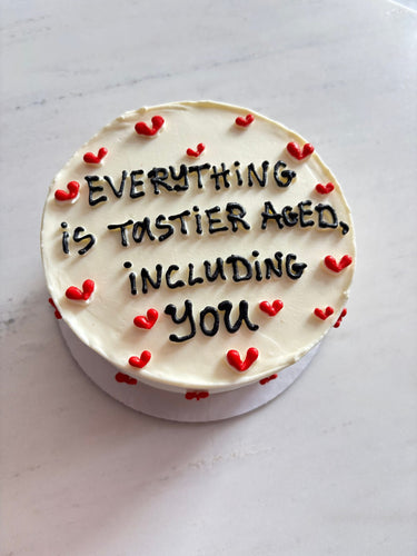 Кръгла кремава торта с рисунка и надпис 'EVERYTHING is TASTIER AGED, INCLUDING you'.