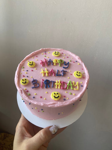 Кръгла розова торта с рисунка и надпис HAPPY HALF BIRTHDAY за полу-рожден ден на бебе.