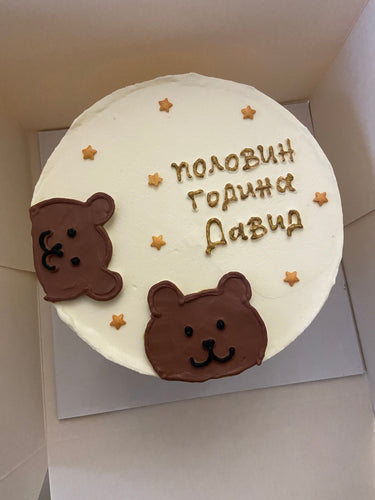 Кръгла бяла торта с рисунка на мече и златен надпис за бебе.