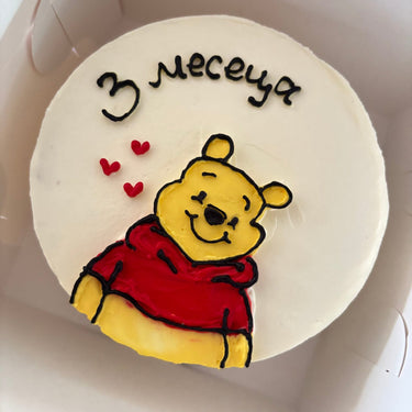 Кръгла бяла торта с рисунка на Мечо Пух за месечинка на бебе.