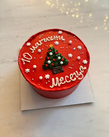 Кръгла червена торта с коледна рисунка и перлена украса за бебешка месечинка.