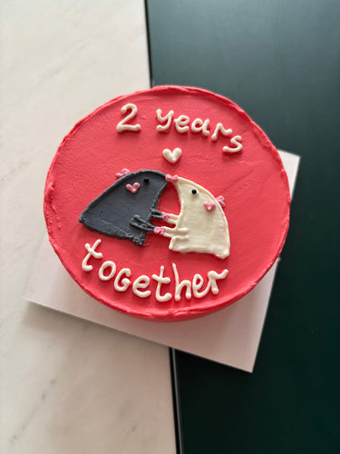 Кръгла червена торта с рисунка и надпис 2 years together.