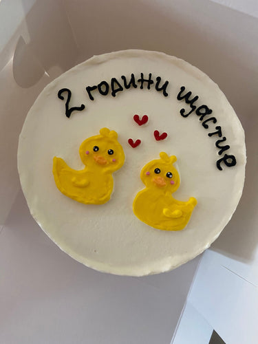 Кръгла бяла торта с рисунка и надпис '2 години щастие' за годишнина