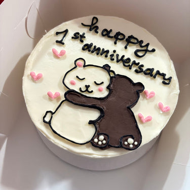 Кръгла бяла торта с ръчна рисунка и надпис 'happy 1st anniversary'