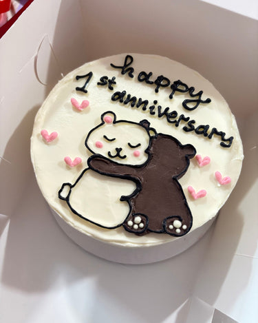 Кръгла бяла торта с ръчна рисунка и надпис 'happy 1st anniversary'