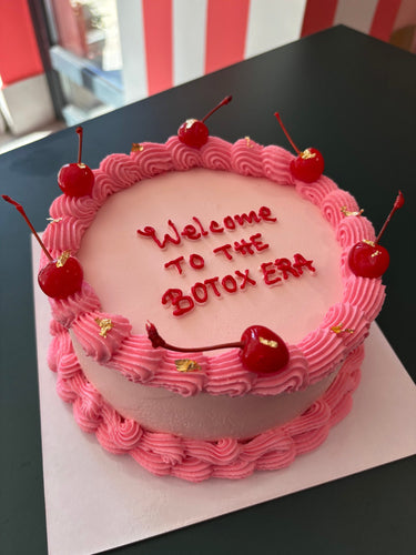 Розова кръгла торта с черешки, кремав кант, брокат и надпис 'Welcome TO THE BOTOX ERA'