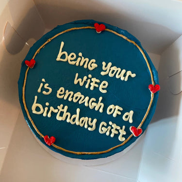Кръгла синя торта с надпис в злато 'being your wife is enough of a birthday gift'