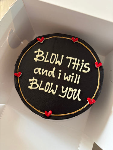 Кръгла черна торта с кремав кант и златен надпис 'BLOW THIS and i will BLOW you'
