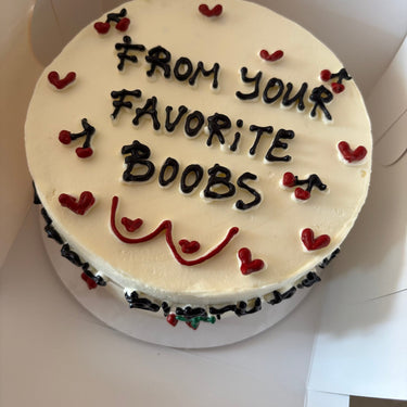Бяла кръгла торта с хумористична рисунка и надпис 'FROM YOUR FAVORITE BOOBS'