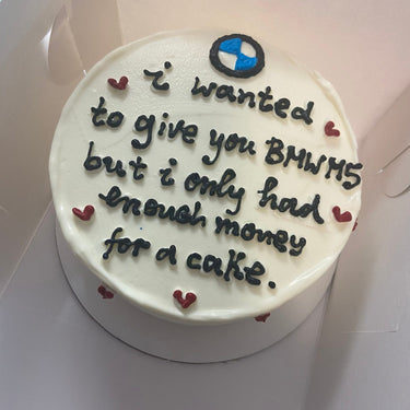 Кръгла бяла торта с рисунка и надпис 'I wanted to give you BMW M5 but I only had enough money for a cake'