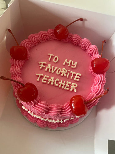 Кръгла розова торта с черешки, кремав кант и надпис 'To my Favorite Teacher'.