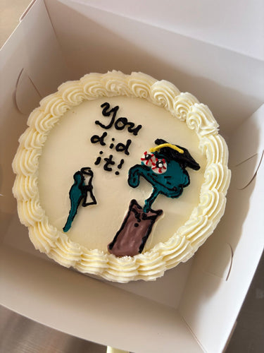 Кръгла бяла торта с рисунка на Squidward, кремав кант и надпис 'You did it!'