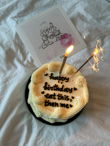 Кръгла бяла торта с кремав кант и надпис 'happy birthday eat this, then me'