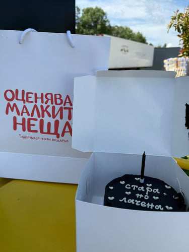 Кръгла черна торта с надпис 'стара по лачена', без допълнителна украса.