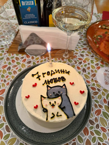 Кръгла кремава торта с ръчна рисунка и надпис '7 години любов' за годишнина.