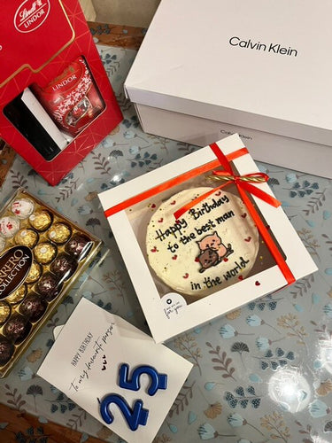 Кръгла бяла торта с ръчна рисунка и надпис 'Happy Birthday to the best man in the world'.
