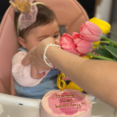 Кръгла бебешко розова торта с надпис "Happy half birthday", златен надпис и брокат.
