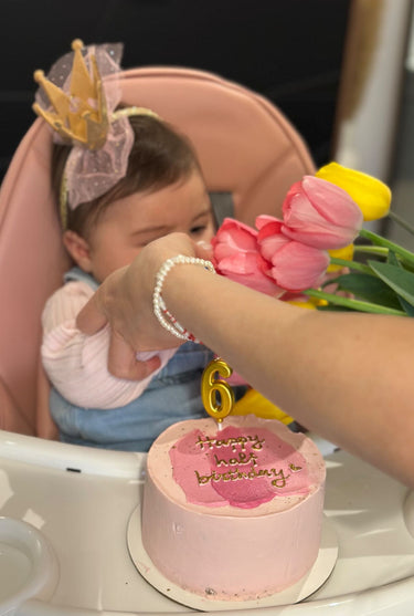 Кръгла бебешко розова торта с надпис "Happy half birthday", златен надпис и брокат.
