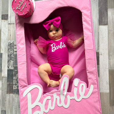 Кръгла розова торта с надпис Barbie и украса от перли.