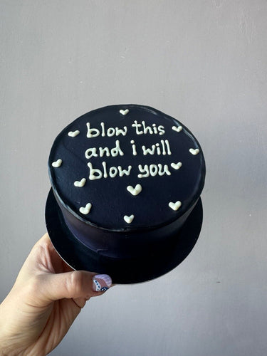 Кръгла черна торта с бял надпис 'blow this and i will blow you'