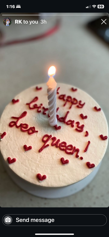 Кръгла кремава торта с надпис 'Happy Birthday, Leo queen!' на повърхността, без допълнителна украса.