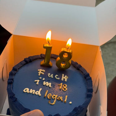 Кръгла торта с морскосиня глазура, кремав кант и златен надпис "Fuck I'm 18 and legal"