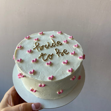 Кръгла бяла торта с златен надпис bride to be
