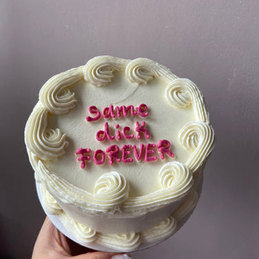 Кръгла бяла торта с кремав кант и надпис "same dick FOREVER".