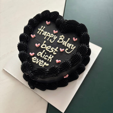 Черна торта във форма на сърце с кремав кант и надпис Happy Bday best dick ever