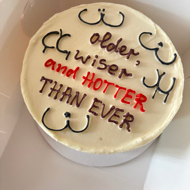 Round white cake with an illustration and the message older, wiser and HOTTER THAN EVER