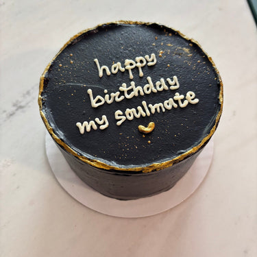 Кръгла черна торта с брокатна украса и златен надпис "happy birthday my soulmate"