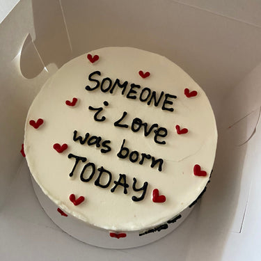 Кръгла бяла торта с надпис 'Someone i Love was born TODAY'.
